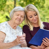Women with caregiver reading and sparking her life