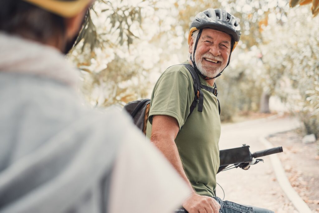 twohappyoldmaturepeopleenjoyingandridingbikestogether