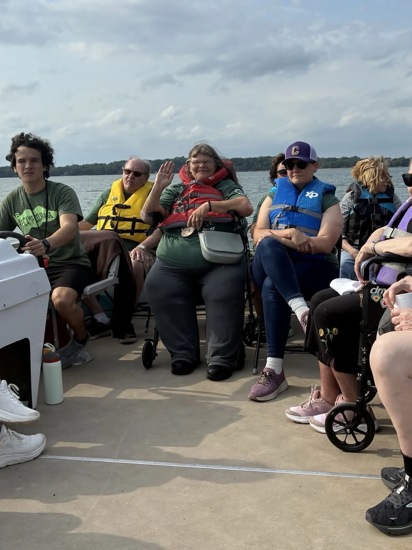 Campers gather on an accessible pontoon boat during a lake excursion at Camp Joy.